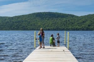 Des parents montrent à leurs jeunes enfants à pêcher à partir d'un quai.