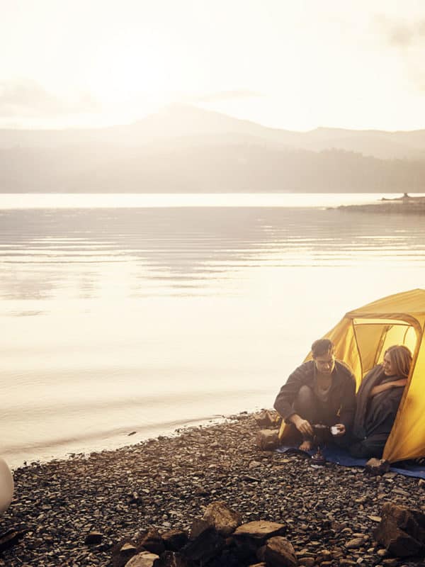 2 campeurs ont installé leur tente au bord de l'eau.
